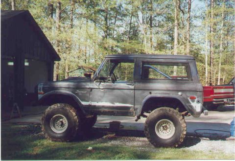 1974 Ford Bronco - Side view of a 1974 Ford Bronco with large tires and a hardtop.