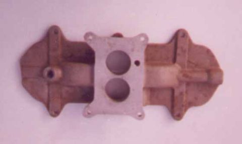 1972 Ford Ranchero - This dual-plane intake manifold features a central mounting plate with two circular openings for carburetor attachment.