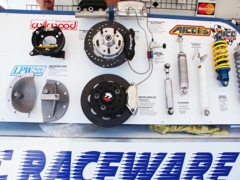 2001 Mercury Grand Marquis - A display board showcases various racing parts including disc brakes, shocks, and brake kits from brands like Wilwood and Afco.