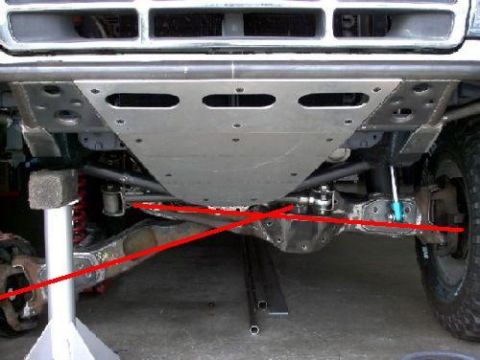 1984 Ford Bronco - The front suspension and skid plate of a modified truck are visible from below.