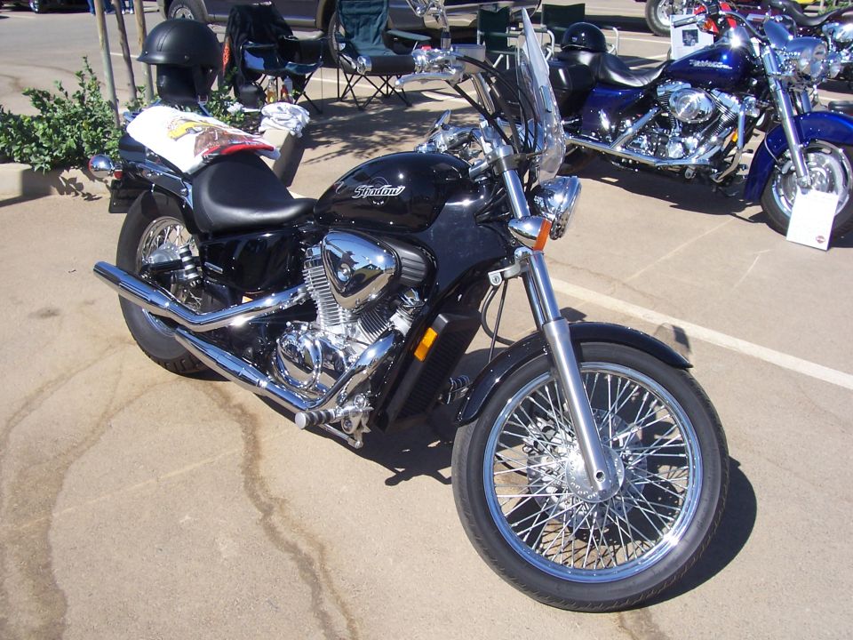 Black motorcycle with chrome accents and a windshield parked outdoors