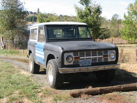 1991 Ford Explorer - This classic Ford Bronco is parked outdoors on a sunny day, showing its distinctive front grille and two-tone paint job.