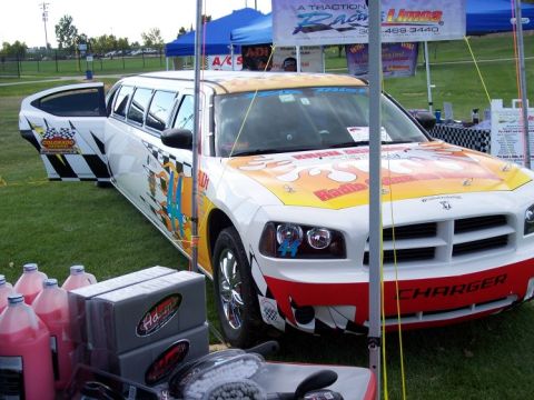 1972 Ford Ranchero - A custom-built limousine based on a Dodge Charger is parked on grass with promotional tents in the background.