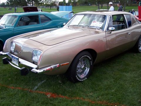 1972 Ford Ranchero - A 1974 Avanti II is displayed at an outdoor car show with other vehicles in the background.