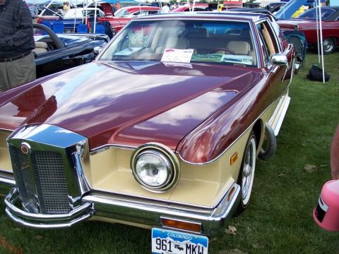 1972 Ford Ranchero - A two-tone car with a prominent chrome grille is displayed at an outdoor car show.