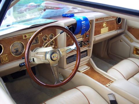 1972 Ford Ranchero - The interior of a luxury car features wood grain accents and plush seating, adorned with a blue award ribbon.