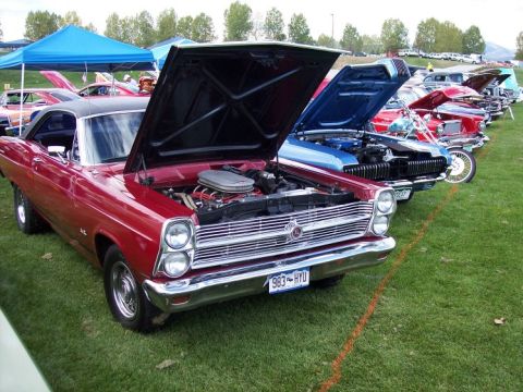 1972 Ford Ranchero - A line of classic cars, including a red 1966 Ford Fairlane GT, are displayed with hoods open at a car show.