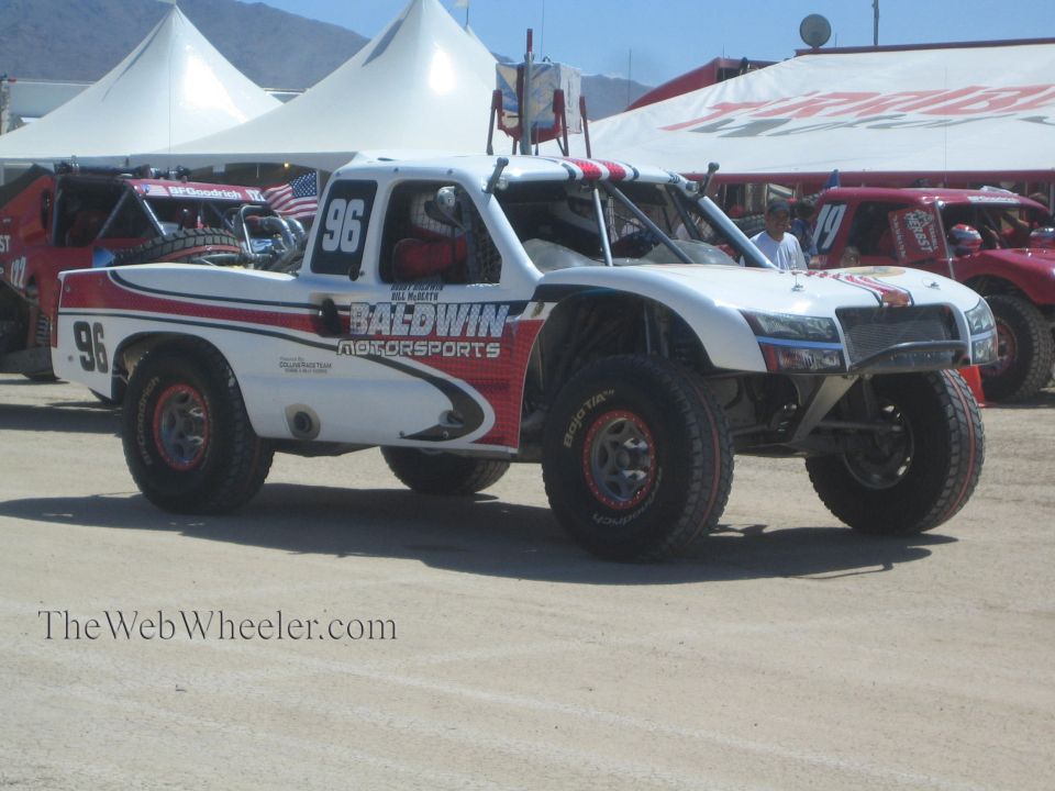 White and red Baldwin Motorsports off-road race truck number 96 in a pit area
