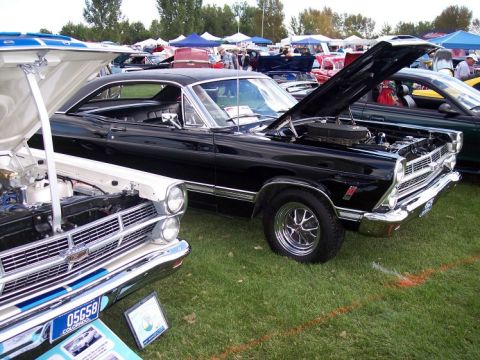 1972 Ford Ranchero - Two classic cars are displayed on a grassy field with tents in the background at an outdoor event.