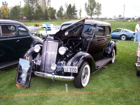 1972 Ford Ranchero - A black 1937 Packard sedan is displayed with its hood open, alongside a sign detailing its history.