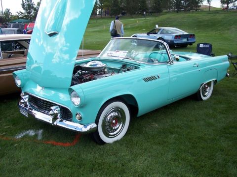 1972 Ford Ranchero - A turquoise 1955 Ford Thunderbird convertible is displayed with its hood open at an outdoor car show.