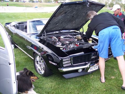 1972 Ford Ranchero - A black 1969 Chevrolet Camaro convertible is displayed with its hood open, revealing the engine compartment. An "RS" badge is visible on th…