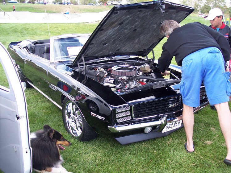 Black 1969 Chevrolet Camaro convertible with hood open, showing engine. "RS" badge visible