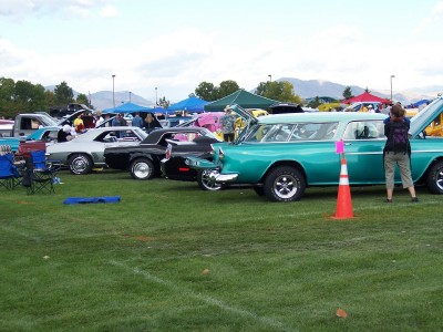 1972 Ford Ranchero - A teal station wagon is parked on a grassy field at an outdoor car show.
