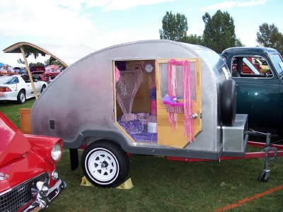 1972 Ford Ranchero - Interior view of a decorated teardrop trailer at an outdoor event with other vehicles present.