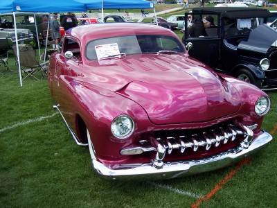 1972 Ford Ranchero - Customized 1950s coupe with a distinctive grille and hood scoop, displayed at an outdoor event.