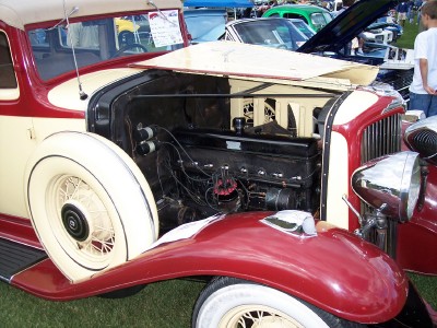 1972 Ford Ranchero - A classic car with its engine exposed is displayed at an outdoor event with other vehicles present.
