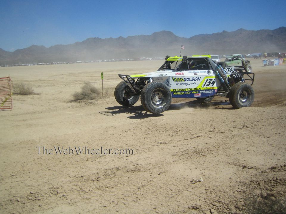 White and yellow off-road race buggy number 134 with Wilson livery on desert course