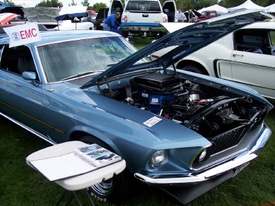 1972 Ford Ranchero - Blue 1969 Ford Mustang Mach 1 displayed with its engine exposed at an outdoor car show.