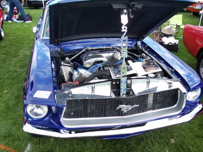 1972 Ford Ranchero - A blue 1969 Ford Mustang is displayed with its hood open, revealing the engine and a prominent chrome grille.