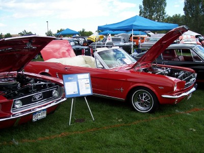 1972 Ford Ranchero - A red 1965 Ford Mustang convertible is displayed with its hood open at an outdoor car show.
