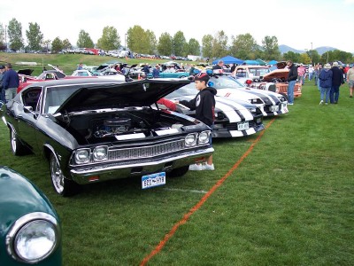 1972 Ford Ranchero - Cars are displayed on a grassy field at an outdoor event, with several vehicles having their hoods open.