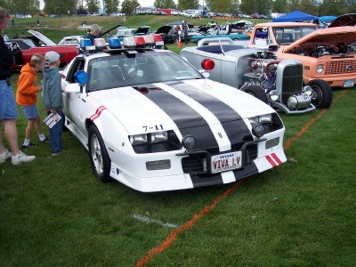 1972 Ford Ranchero - Modified police car on display at an outdoor car show with other vehicles present.