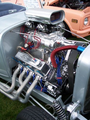 1972 Ford Ranchero - A highly polished V8 engine with custom exhaust headers is the focus of this image, with other vehicles visible in the background.
