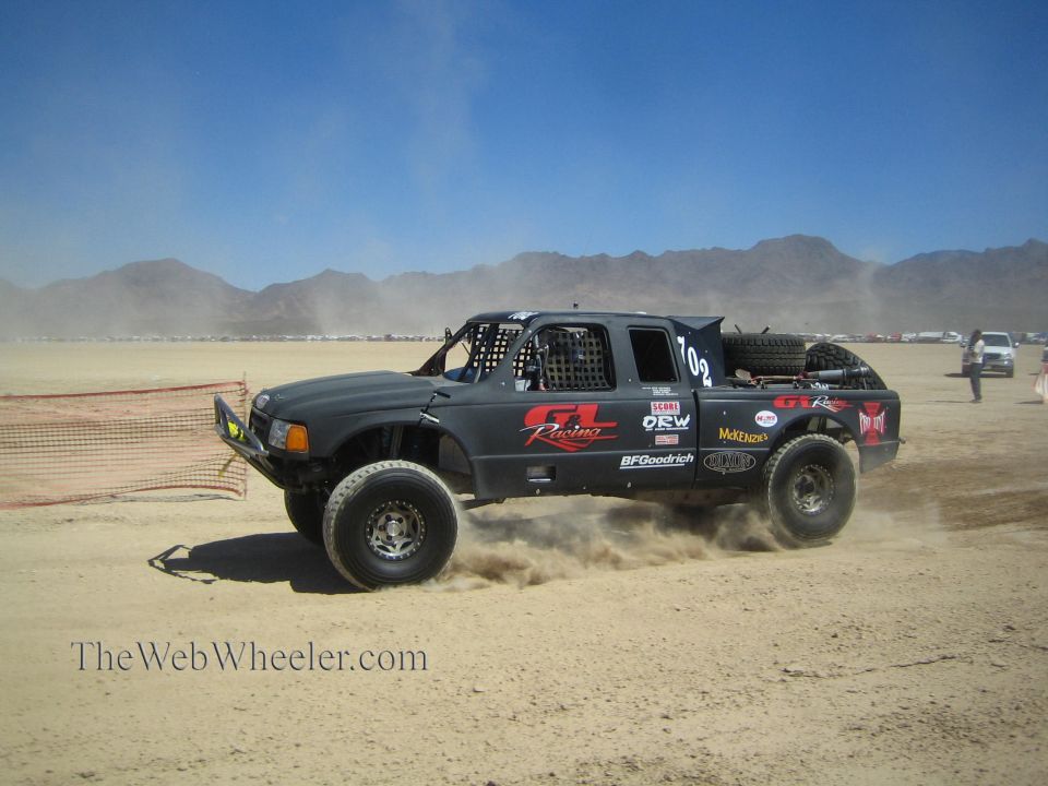 Black GR Racing off-road truck #102 racing through desert dust
