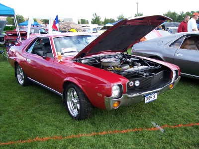 1972 Ford Ranchero - A red 1970 AMC AMX is displayed with its hood open at an outdoor car show.