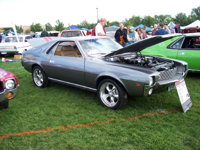 1972 Ford Ranchero - A gray 1970 AMC AMX is displayed at an outdoor car show with its hood open, revealing the engine.