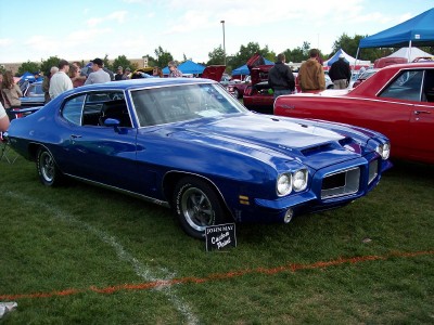 1972 Ford Ranchero - A blue coupe with a distinctive front grille and hood scoop is displayed at an outdoor event.