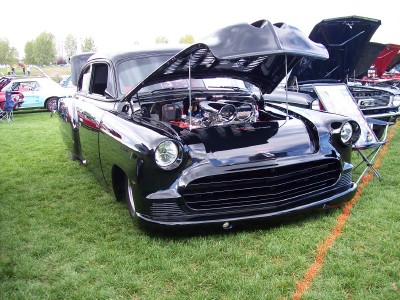 1972 Ford Ranchero - A custom black coupe with its hood raised reveals a polished engine at an outdoor car show.