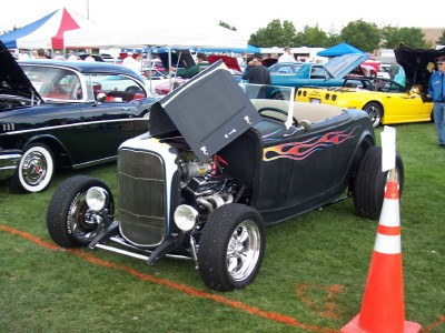 1972 Ford Ranchero - Hot rod with flames on display at an outdoor car show, with other vehicles present.