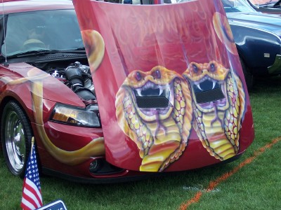 1972 Ford Ranchero - A custom-painted car with cobra graphics on the hood is displayed with its engine visible.