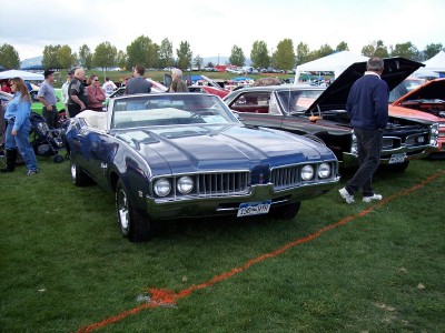 1972 Ford Ranchero - Blue convertible at a car show, with other vehicles and people in the background. The year is estimated to be 1970.