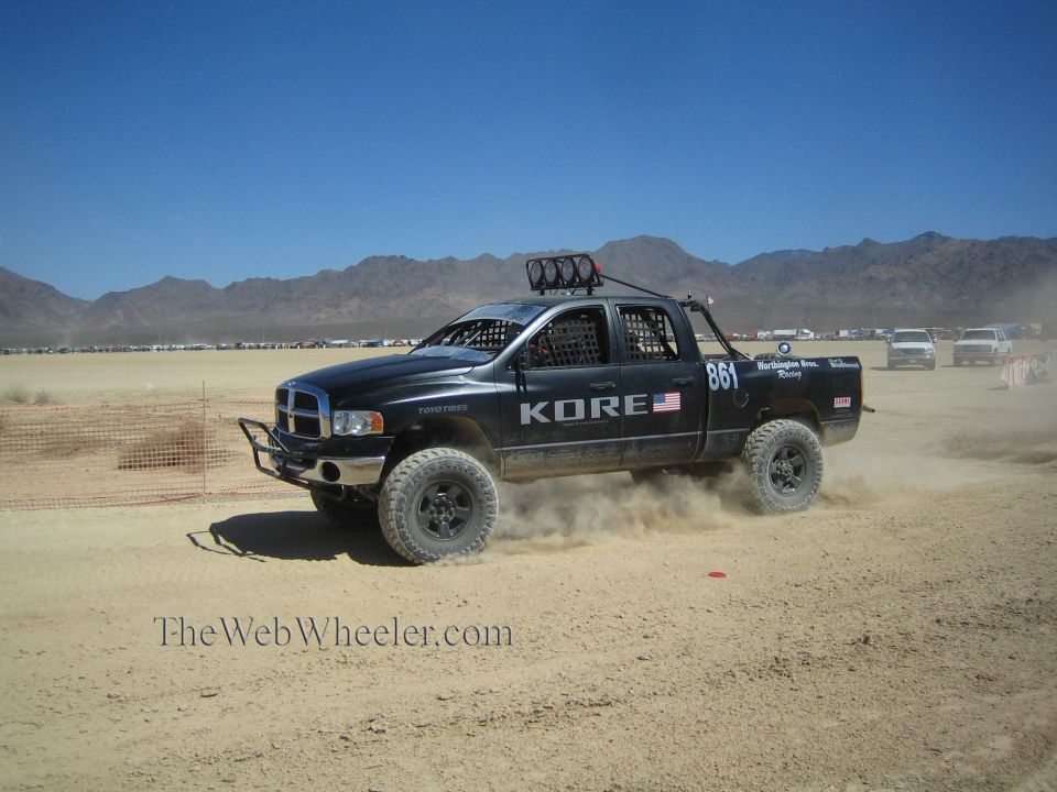 Black Dodge Ram off-road race truck #861 racing through the desert