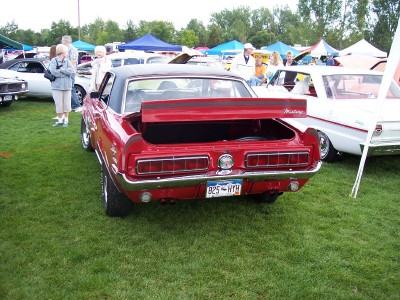 1972 Ford Ranchero - Rear view of a red coupe with its trunk open, parked on grass at an outdoor event.