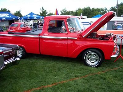 1972 Ford Ranchero - A red pickup truck is displayed with its hood open at an outdoor event.