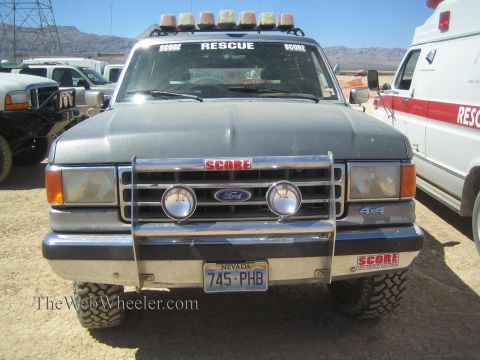 1990 Ford Bronco - Front view of a gray Ford SCORE Rescue truck with a brush guard, light bar, and Nevada plate 745-PHB.
