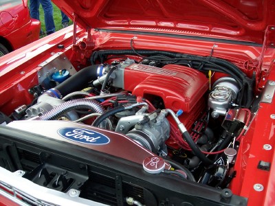 1972 Ford Ranchero - The engine compartment of a red vehicle is open, revealing a Ford engine and various components.