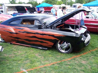 1972 Ford Ranchero - A customized coupe with a distinctive tiger stripe paint job is displayed at an outdoor event.