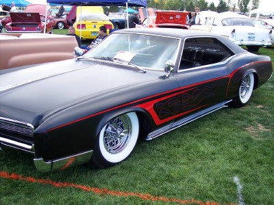 1972 Ford Ranchero - A custom 1972 Buick Riviera with flame decals and chrome accents sits on display at a car show.