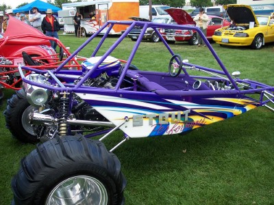 1972 Ford Ranchero - A custom purple dune buggy with striking graphics is displayed on a grassy field at an outdoor event.