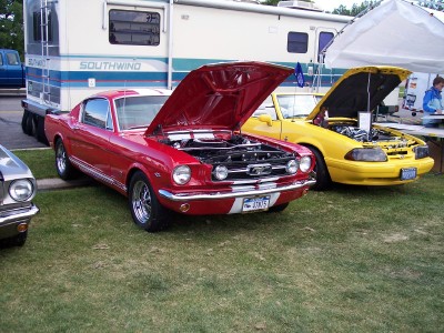 1972 Ford Ranchero - Two Ford Mustangs, one red and one yellow, are displayed with their hoods open at an outdoor event.
