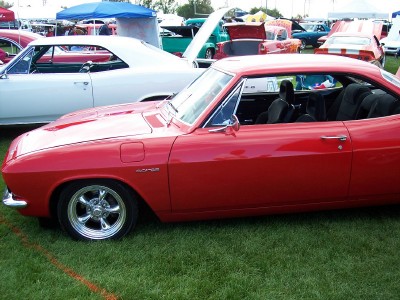 1972 Ford Ranchero - Side view of a red coupe with custom wheels at an outdoor car show.