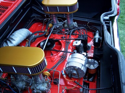 1972 Ford Ranchero - The engine bay features dual carburetors and custom air filters, set against a vibrant red painted background.