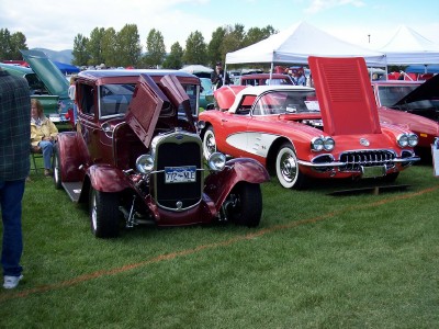 1972 Ford Ranchero - A maroon sedan is parked on a grassy field with its hood open, displaying its license plate.