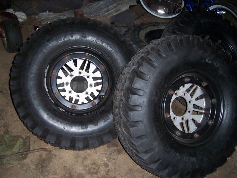 1983 Ford Bronco - Two large off-road tires with custom multi-spoke rims are shown, likely for an off-road vehicle.