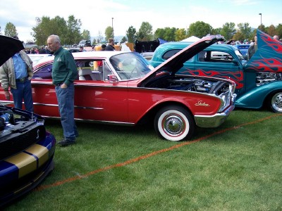 1972 Ford Ranchero - Two classic cars are parked on grass at an outdoor event, both with hoods raised.